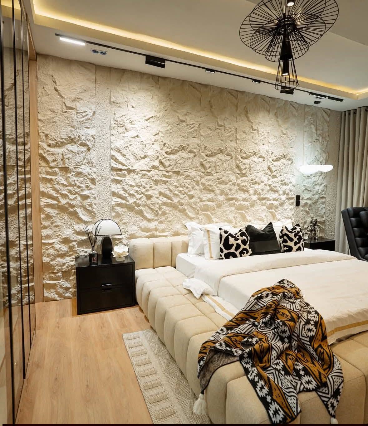 Bedroom with natural stone feature wall and upholstered bed